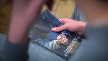 Prisoner-with-prayer-book-in-his-cell